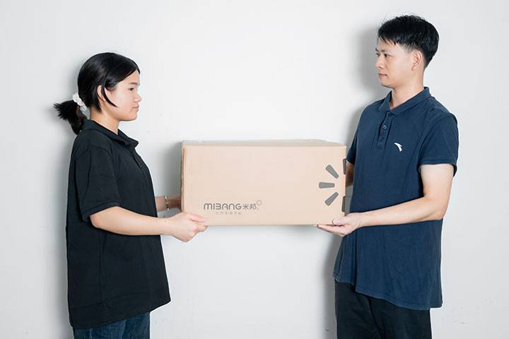 2 people are holding the paper box